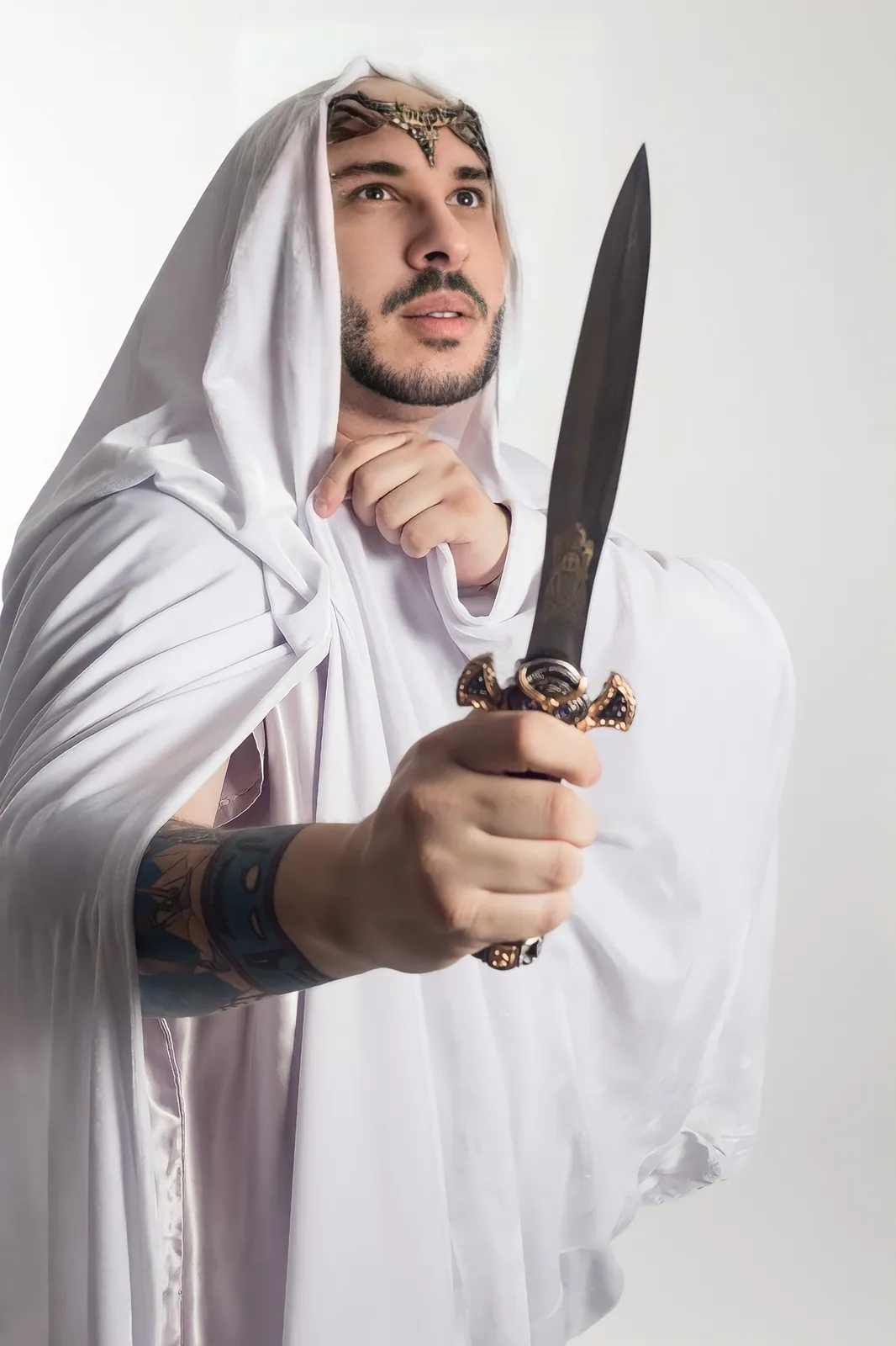 Claudiney Prieto de manto branco e tiara, segurando um athame